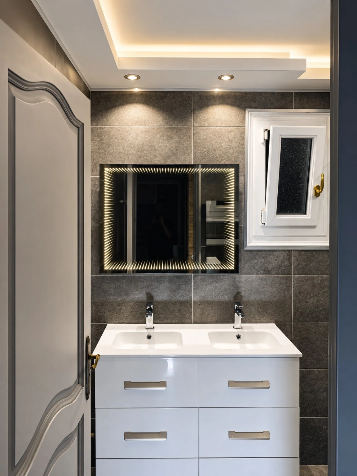 Meuble double vasque, miroir et éclairage dans une salle de bain rénovée